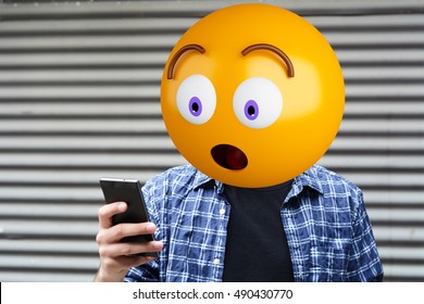 Surprise Emoji Head Man Using A Smartphone. Emoji Concept