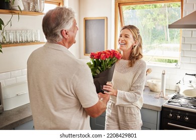 Surprise Flowers, Love Celebration And Couple With Smile To Celebrate Birthday, Anniversary Or Romantic Event In Home Kitchen. Senior Man And Woman Giving Bouquet Of Roses As Present Or Gift