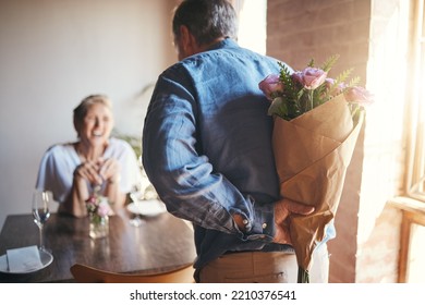 Surprise, flowers and senior couple in celebration of an anniversary, marriage or birthday at a restaurant. Elderly man giving bouquet of roses to woman during dinner date for love at a coffee shop - Powered by Shutterstock