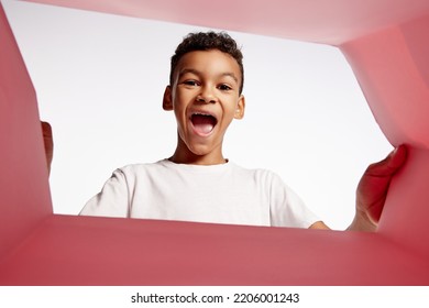 Surprise. Happy Smiling Kid, Little Boy Looking Inside Box During Opening, Unpacking It. Delivery, Surprise, Gift, Wow Emotions Concept. Black Friday, Holidays, Online Shopping