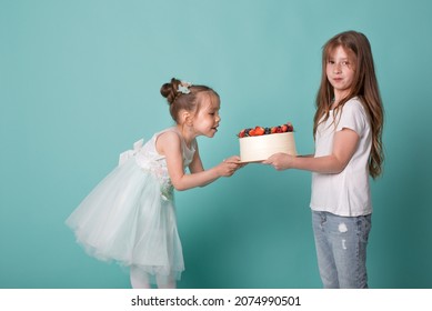 Surprise Of A Large Birthday Cake. Girlfriend Girls Celebrate Their Birthday. Older Sister Brings A Gift To Her Little. Children Are Having Fun And Eating Sweets. Cutie Kid Blows Out Candle On Cake