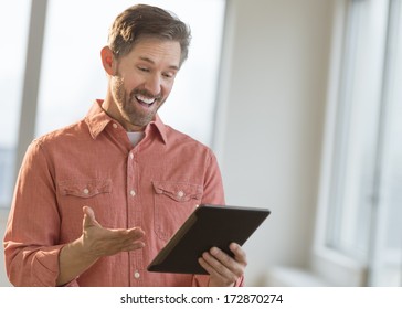 Surprise Mature Man Using Digital Tablet At Home