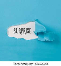 Surprise message on torn blue paper revealing secret behind ripped opening. - Shutterstock ID 582695953