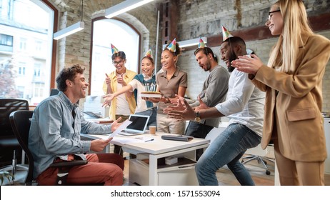 Surprise. Mixed race happy people celebrating a birthday of colleague in the modern office - Powered by Shutterstock