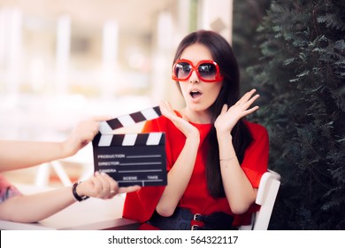 Surprised Actress with Oversized Sunglasses Shooting Movie Scene - Diva in red dress and big shades starring in an artistic film
