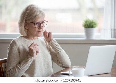 Surprised Aged Woman Using Laptop Worried Seeing Error Message On Screen, Concerned Senior Female Get Unexpected Computer Notification Or Warning, Confused Witnessing Breakdown Or Virus Attack