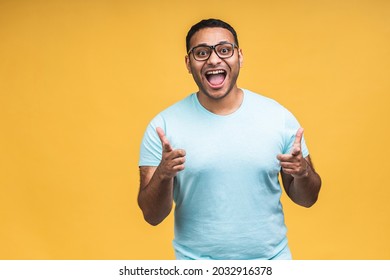 Surprised Amazed African American Indian Man Guy In Casual Isolated Over Yellow Background Studio Portrait. People Lifestyle Concept. Mock Up Copy Space. Keeping Mouth Open.