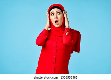  surprised arab woman holding her head on a blue background                              