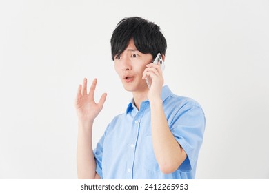 Surprised Asian man with the smartphone in white background - Powered by Shutterstock