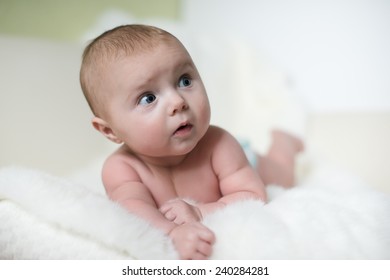 The surprised baby lying on white towel, cheerful, health, indoors, pretty