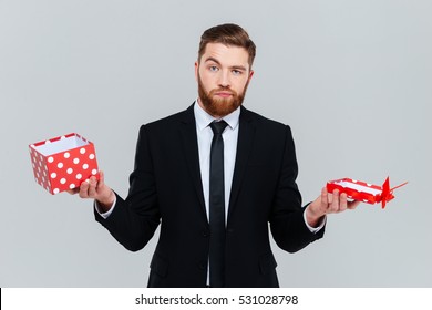 Surprised Bearded Business Man In Suit Holding Empty Open Gift In Hands. Isolated Gray Background