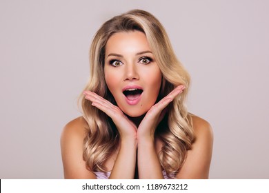 Surprised beautyful woman with opened mouth and blond hair. Woman in shock. Surprising facial emotions