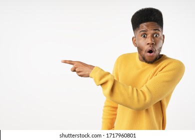Surprised Black Man Pointing Finger At Copy Space Isolated On White Studio Background