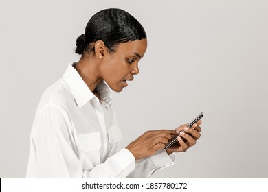 Surprised black woman using a mobile phone