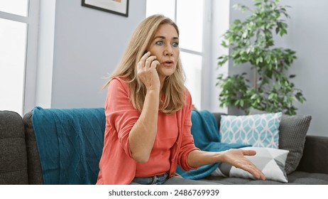 A surprised blonde woman talking on the phone in a modern living room, expressing worry or disbelief. - Powered by Shutterstock