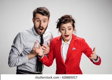 The Surprised Business Man And Woman Smiling On A Gray Background