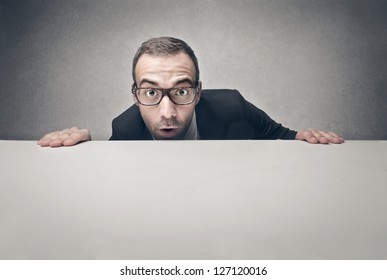 surprised businessman with blank billboard - Powered by Shutterstock