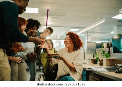 A surprised businesswoman is having a birthday party with cake and celebrating with diverse colleagues. A multiracial and inclusive coworkers making a bday surprise party at office. Birthday at office - Powered by Shutterstock