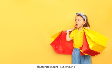 Surprised child girl in summer clothes hold package bag with purchases isolated on yellow background studio. Shopping discount sale concept. Mock up,copy space, banner. Black friday