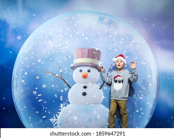 Surprised child inside a Christmas snow globe. Snowman and little Santa Clause under the snowflakes. Merry Christmas and happy new year holidays. Kid boy in magic place on holidays. - Powered by Shutterstock