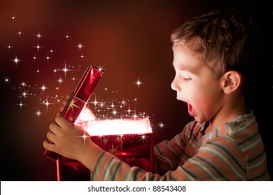 A Surprised Child Opening And Looking Inside A Magic Gift