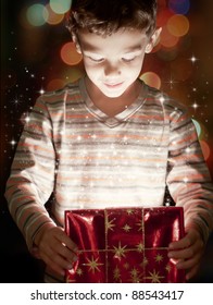 A Surprised Child Opening And Looking Inside A Magic Gift