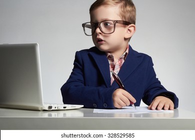 surprised child.Young business boy in office. funny kid in glasses writing pen