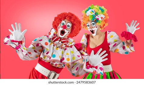 Surprised clowns, man and woman entertainers as Joker in a suit and wig, with clown whiteface makeup. Trickster, jester, pantomime, mime, and a professional actors at events, birthday party