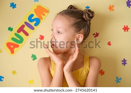 Surprised, concerned about the problem of perceiving special children, the girl looks at the inscription autism