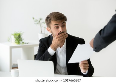 Surprised Confused Caucasian Employee Receiving Dismissal Notice, Letter Or Document With Unexpected News From African Boss, Worried Shocked Office Worker Getting Fired In Written Message At Work