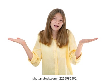 Surprised and confused fourteen year old teenager spread hands sideways, know nothing, can't understand something strange, looking puzzled at camera. Young girl posing in studio isolated on white. - Shutterstock ID 2255995591