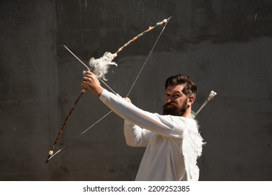 Surprised Cupid Man With Wings Aiming With Bow And Arrow. Funny Valentines Day Concept.