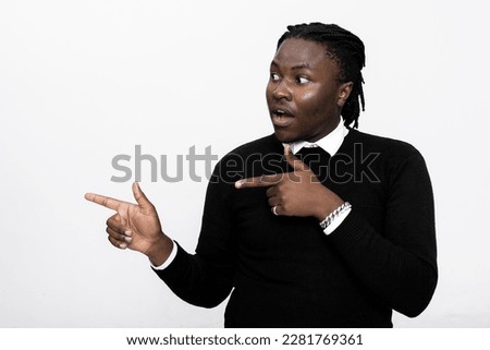 Surprised curious young handsome man over white background in studio isolated pointing directing fingers side empty space banner advertisement concept.
