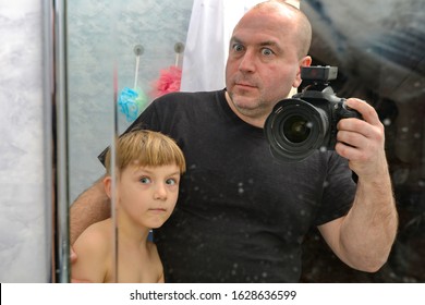 Surprised Dad And Son Are Photographed On A Reflex Camera In Reflection In The Mirror