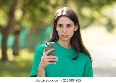 surprised disbelieving girl looking at mobile phone