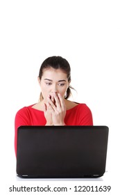 Surprised and disgusted woman working on laptop. Isolated on white.