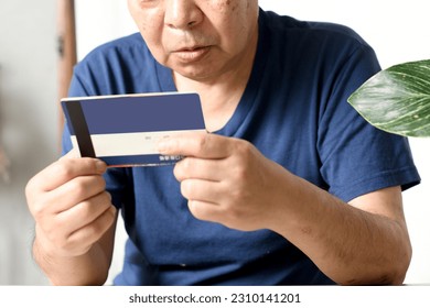 Surprised elderly man looking at bank account passbook
						