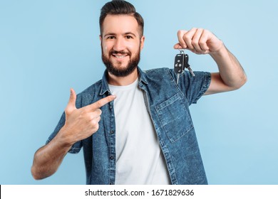 Surprised Excited Happy Man With A Beard Holding Car Keys In His Hands, Standing On An Isolated Blue Background