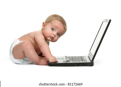 Surprised expression on a baby boys face whilst getting into mischief on a laptop computer