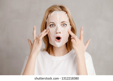 Surprised Face Of Girl In White Cloth Mask For Facial Skin Care.