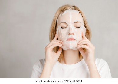 Surprised Face Of Girl In White Cloth Mask For Facial Skin Care.