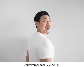 Surprised face of happy asian man in white shirt  light grey background. Face turns around.