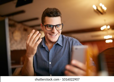 Surprised Freelancer Hipster Man Looks To Smartphone And Can Not Believe He Won Lottery Prize Or Money In Trading Cryptocurrency. Pop-eyed Successfull Amazed Businessman Trader. Video Call Conference