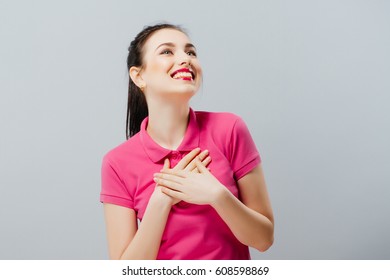 Surprised funny teenage girl showing empty copy space with her finger grey background. Happy girl - Shutterstock ID 608598869