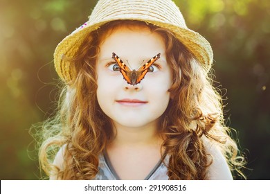 Surprised girl with a butterfly on her nose, focus on a girl's face. Background toning to instagram filter.