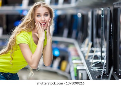 Surprised girl buys a TV in the store