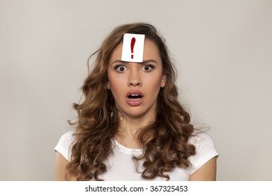 Surprised Girl With Exclamation Mark Drawn On Paper Over Her Forehead