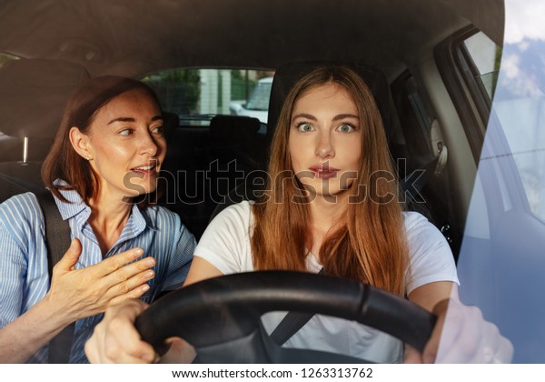 Surprised girl with\
her mother driving a\
car