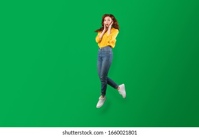 Surprised Girl Jumping In Air Touching Face Posing Over Green Background. Studio Shot, Empty Space For Text - Shutterstock ID 1660021801
