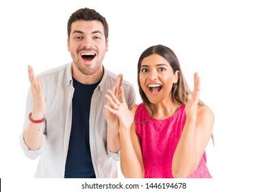 Surprised Good Looking Couple Shouting While Making Eye Contact Against Plain Background